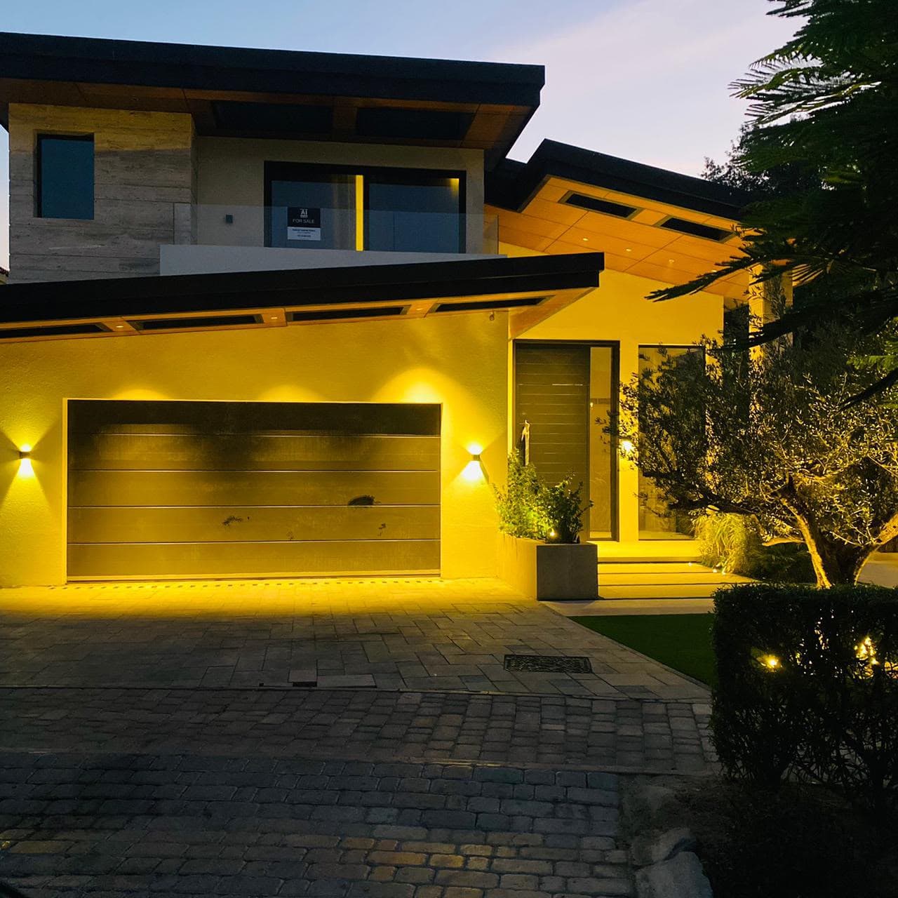 Aluminium garage door and entrance glazing on a UAE villa at dusk