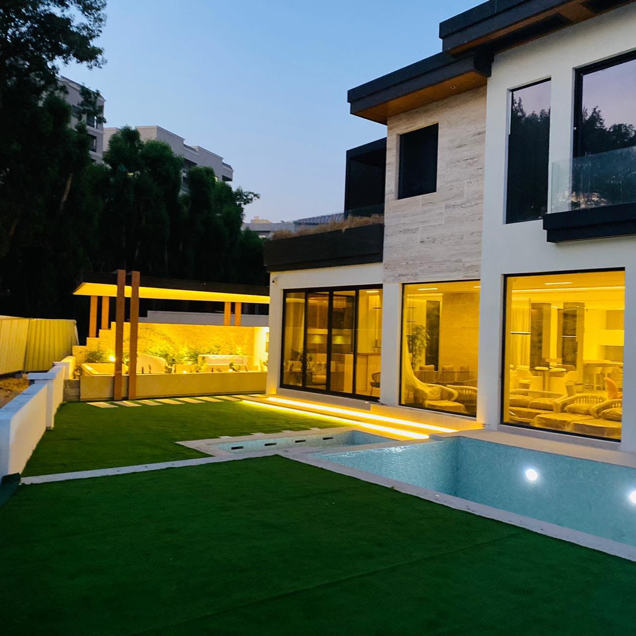 Villa pool and glass sliding doors at dusk