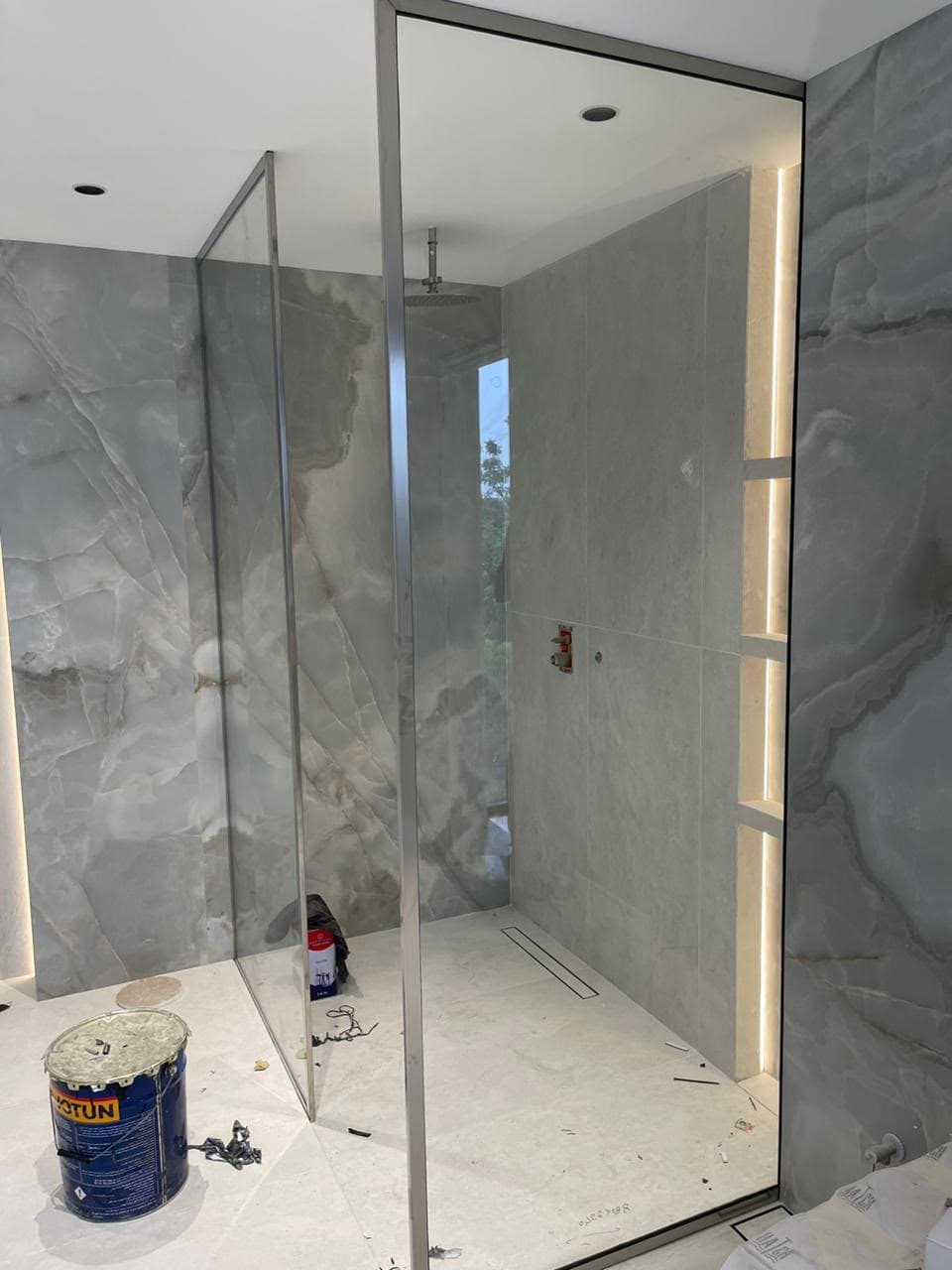 Frameless glass shower enclosure installation