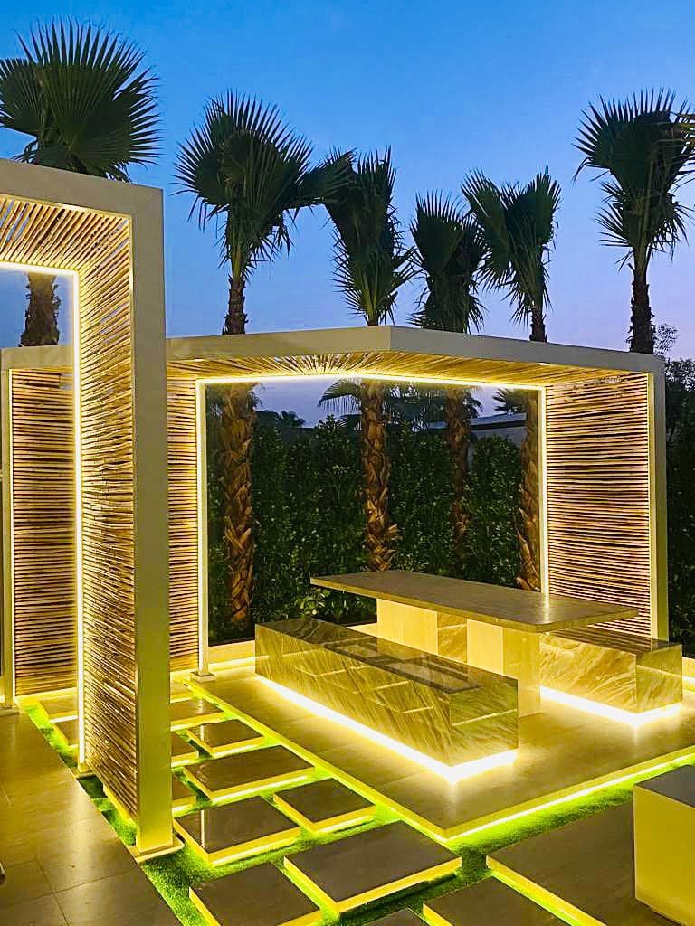 Illuminated aluminium slat pergola over an outdoor dining area