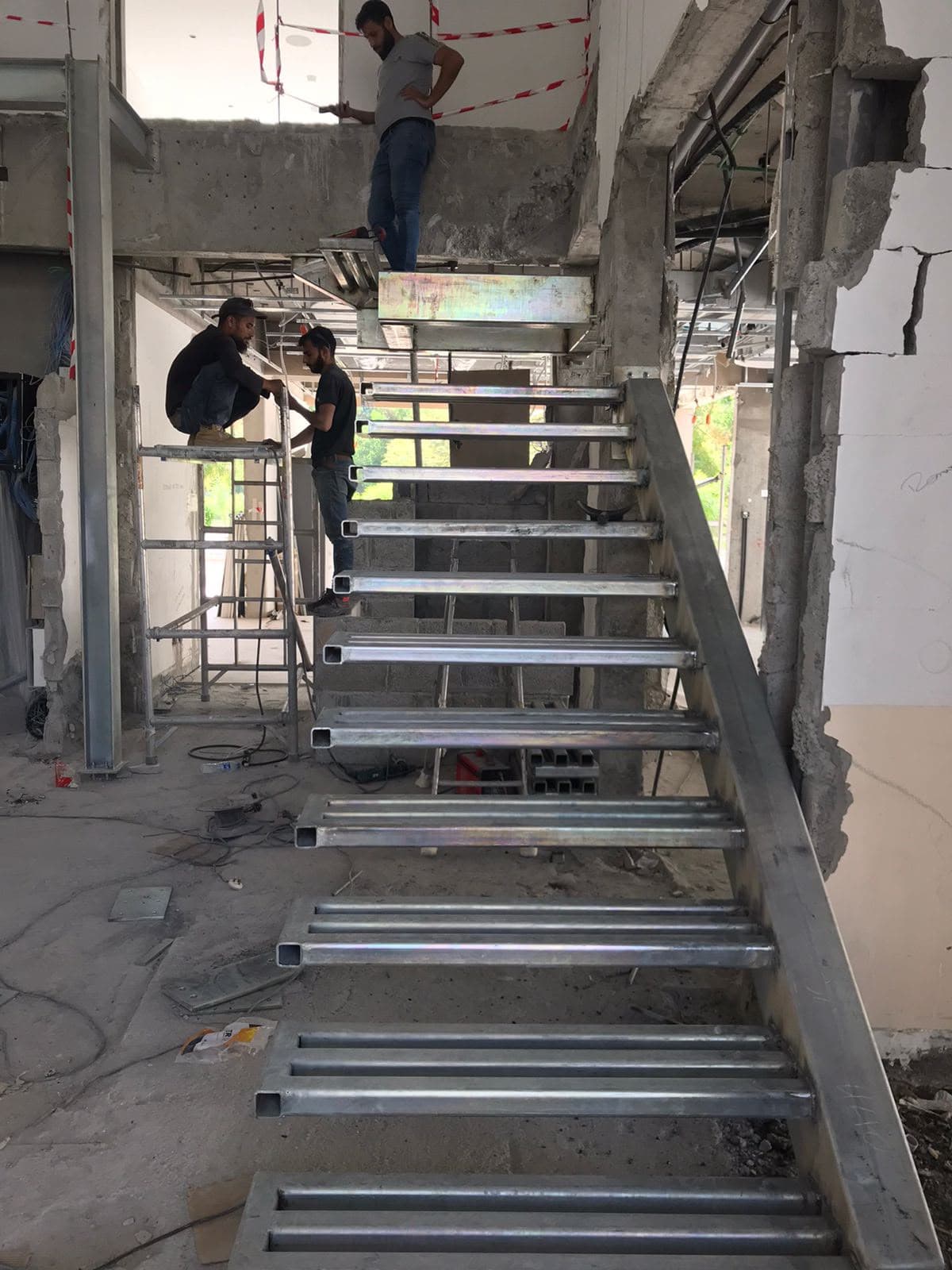 In-house fabrication team assembling a steel and aluminium staircase frame